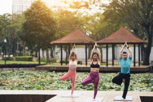 Young Asian people practicing tree pose in the park